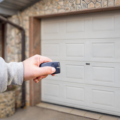 Modesto security key fob pointing to a garage door